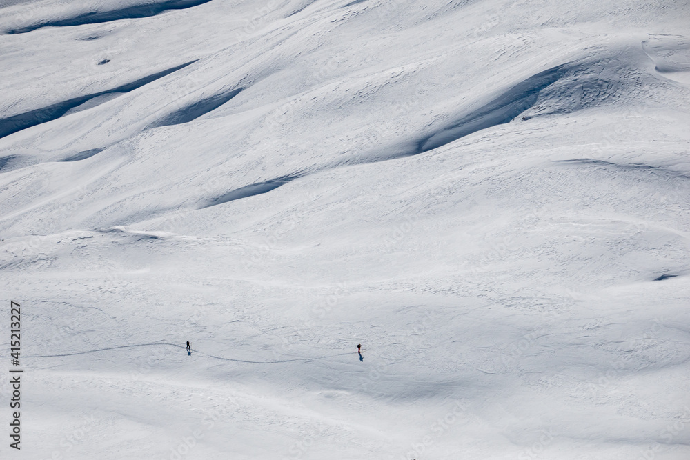backcountry skiers on a snowy slope in the swiss alps