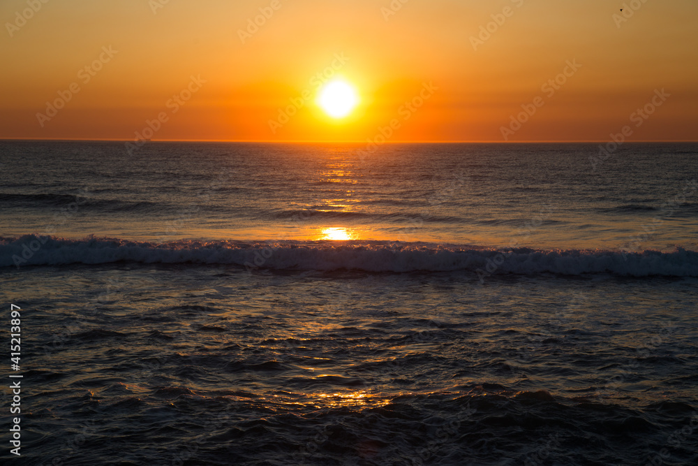 Puesta de sol con colores amarillos y naranjas sobre el Océano Atlántico en Esmoriz (Portugal)