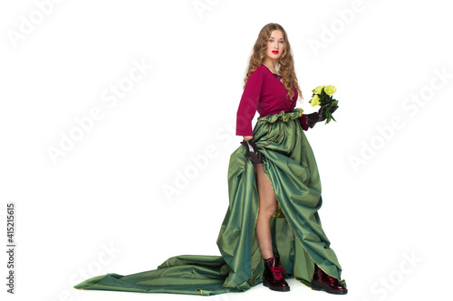 Fashion photo of a beautiful elegant young teenager girl with long curly hair in a pretty long green skirt isolated on white background. © Tanee