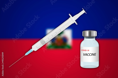 Syringe and vaccine vial on blur background with Haiti flag,