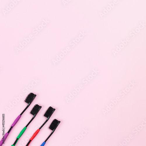 Fototapeta Naklejka Na Ścianę i Meble -  Eco tooth brushes made of biodegradable plastic and bamboo active charcoal bristle on pink background