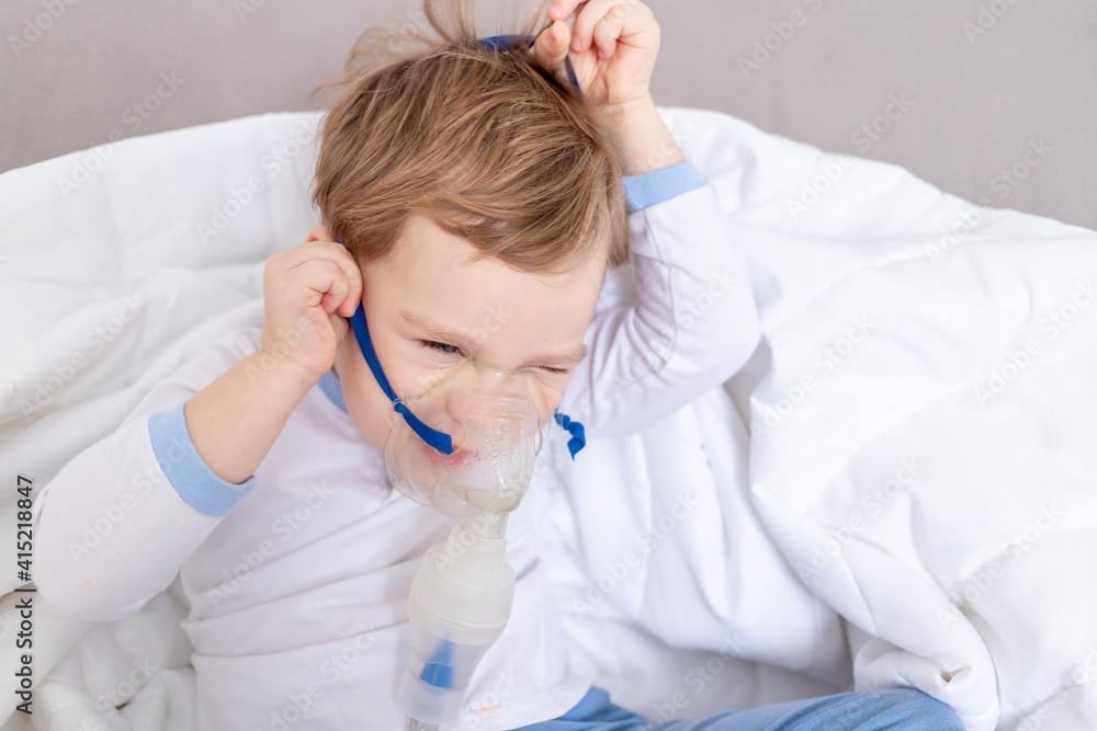 sick child boy takes off the inhaler, does not want to be treated at home, the concept of health and inhalation treatment sick child boy takes off the inhaler, does not want to be treated at home, the concept of health and inhalation treatment