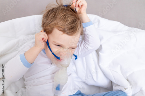 sick child boy takes off the inhaler, does not want to be treated at home, the concept of health and inhalation treatment