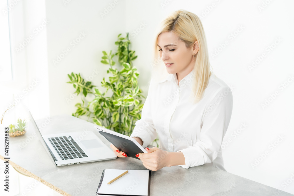 Beautiful young woman working on her laptop in her office.