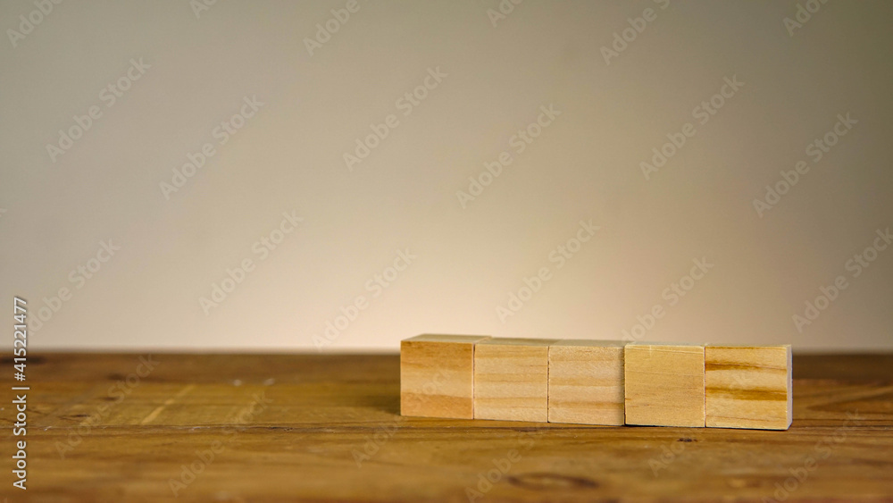 five in line wooden blocks on wooden table five in line wooden blocks on wooden table