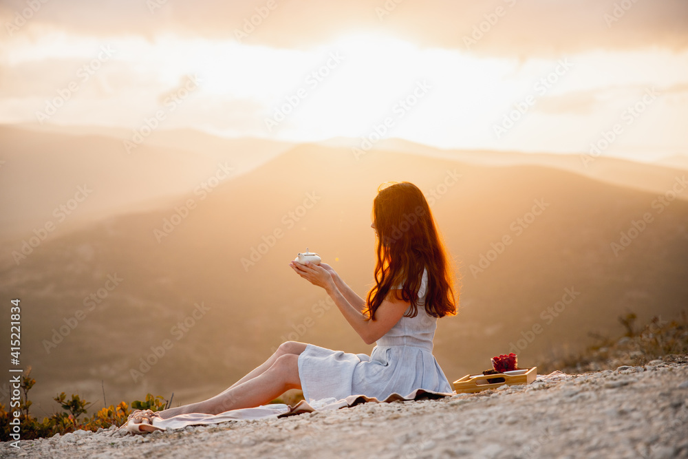 Tea ceremony set with young woman. Sunset in a mountains
