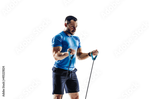 Stretching. Caucasian professional male athlete, runner training isolated on white studio background. Muscular, sportive man. Concept of action, motion, youth, healthy lifestyle. Copyspace for ad.