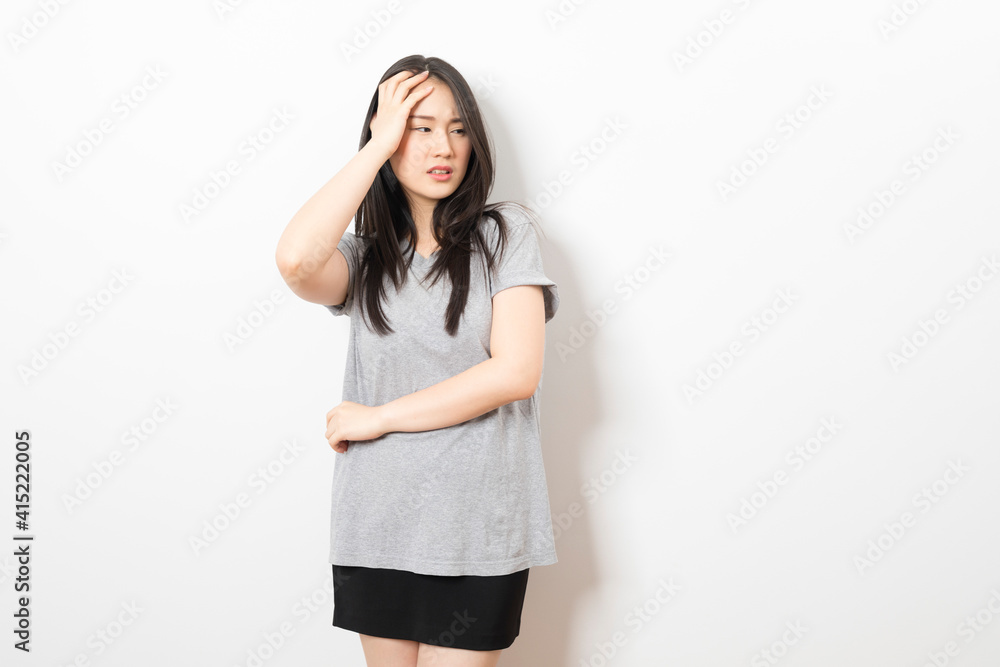 Young Asian woman wearing casual t-shirt with hand on head, headache because stress. suffering migraine. Young Asian woman wearing casual t-shirt with hand on head, headache because stress. suffering migraine.