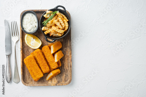 Pile of golden fried fish fingers with white garlic sauce, on wooden tray, on white background, top view flat lay , with copyspace  and space for text