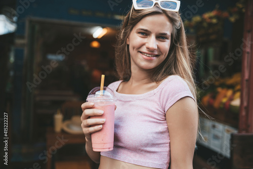 Young blonde woman drinking strawberry shake