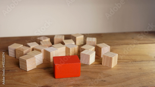 Wooden block surrounding red block. Leadership, teamwork concept.