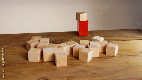 Wooden block surrounding red block. Leadership, teamwork concept.