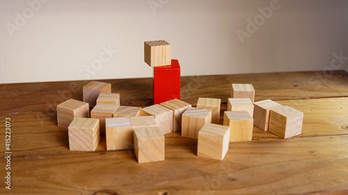 Wooden block surrounding red block. Leadership, teamwork concept.