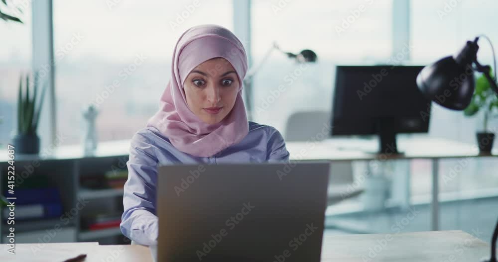 Joyful young arabic businesswoman employee receiving job letter on email rejoicing victory celebrating future success at corporate workspace. Joyful young arabic businesswoman employee receiving job letter on email rejoicing victory celebrating future success at corporate workspace.