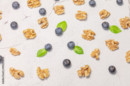 Fresh blueberries and shelled walnuts on a gray background. Natural products concept