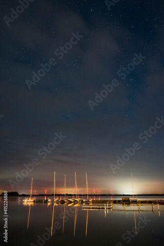 Langzeitbelichtung mit Sternenhimmel und Spiegelung im Wasser am Hafen