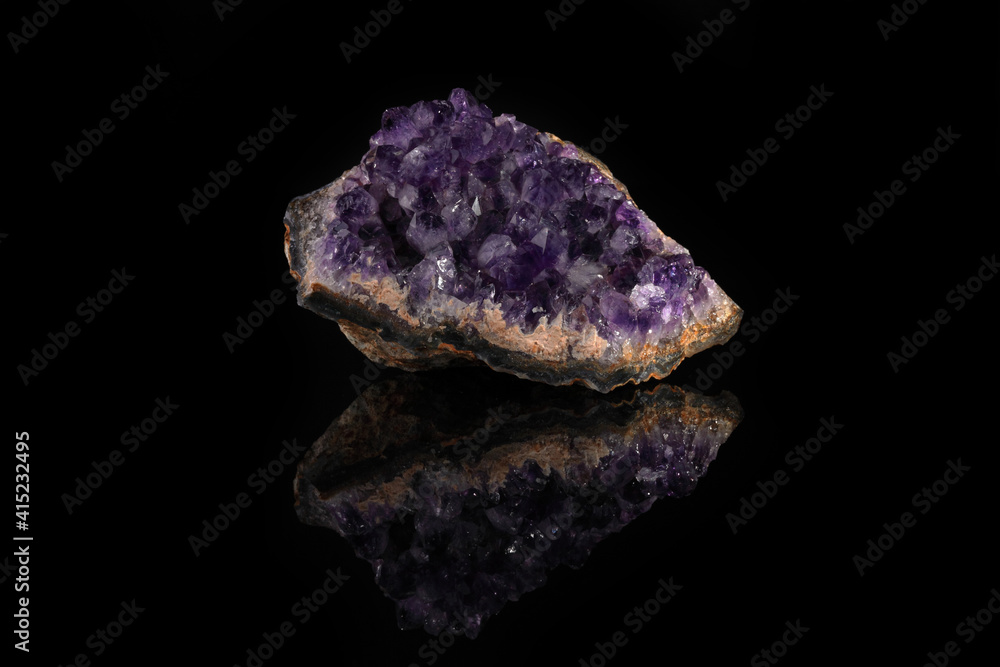 Beautiful amethyst druse close-up on black glass background. Semi precious gem used for jewels.