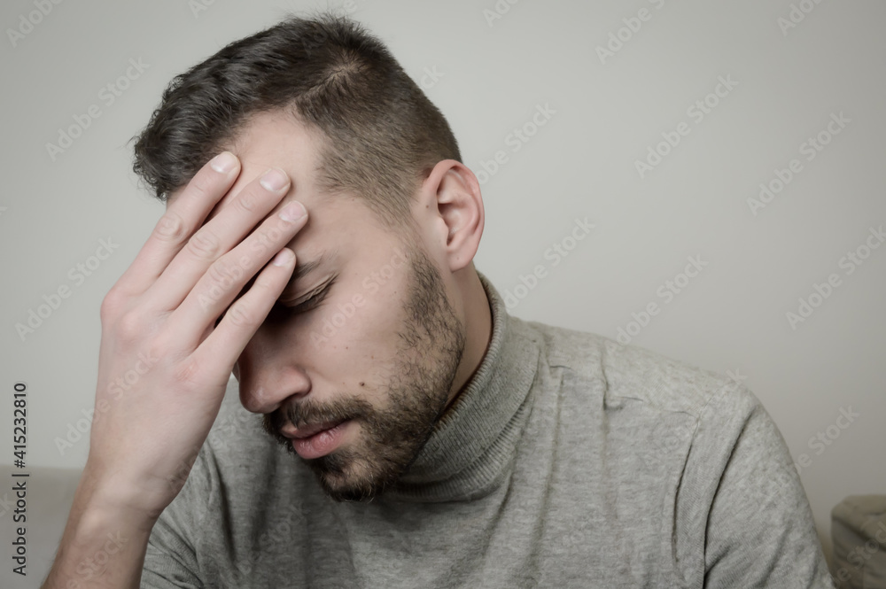 Portrait of a young man touching his forehead to focus or because of an headache Portrait of a young man touching his forehead to focus or because of an headache