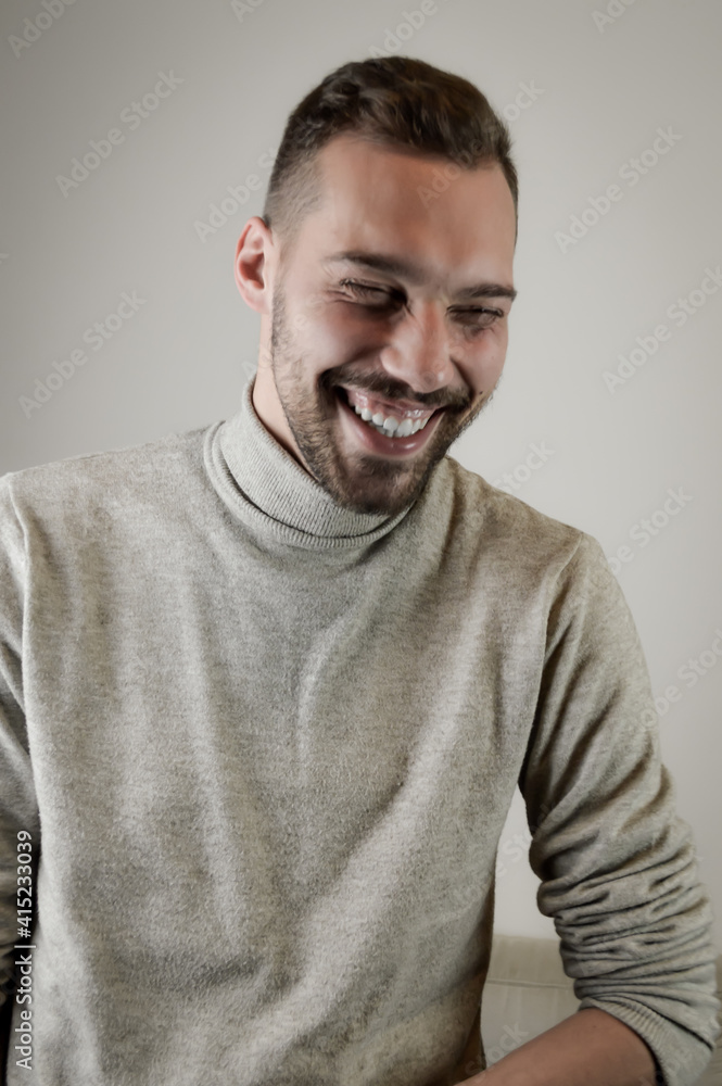 Portrait of a young man with a short beard that laughs cheerfully during a conversation Portrait of a young man with a short beard that laughs cheerfully during a conversation