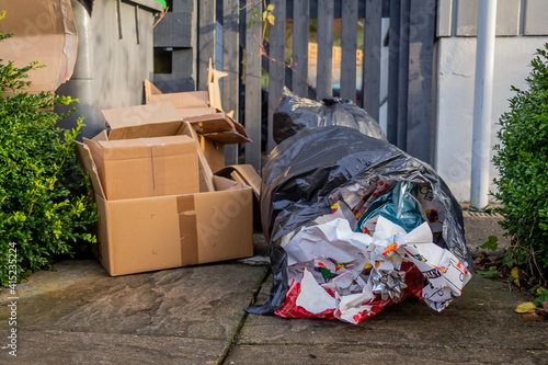 Christmas household waste consisting of boxes and wrapping paper at a trash can