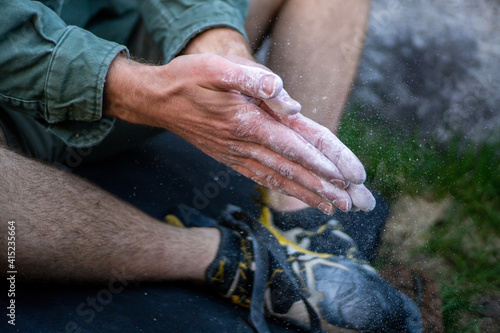 hands of the person about to climb applying chalk