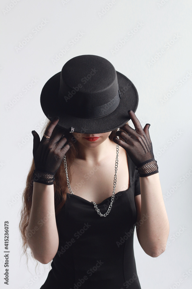 Beautiful slender long-legged brunette girl in a black dress and hat. Beautiful slender long-legged brunette girl in a black dress and hat.