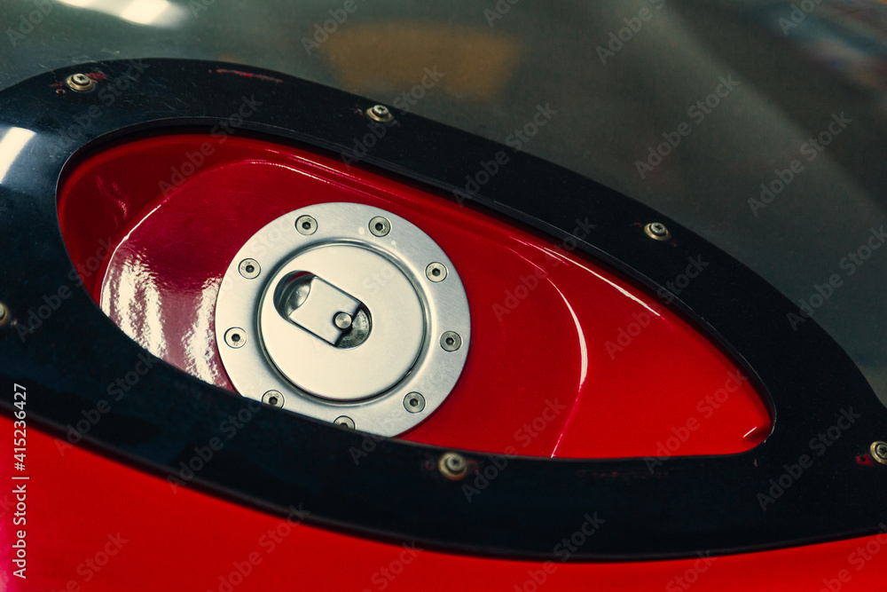 Obraz premium Detail of the red cap from the tank on the car with metallic.