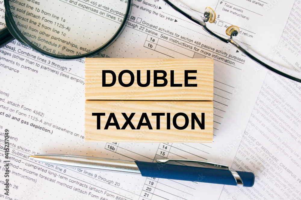 Wooden blocks with text Double Taxation on financial docs Wooden blocks with text Double Taxation on financial docs