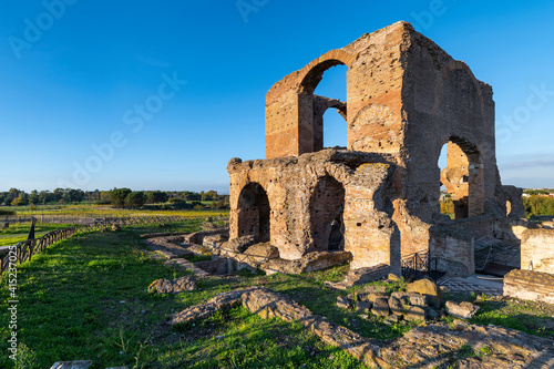 Villa dei Quintili, remains of the thermal baths, of the frigidarium of some mosaics on the Via Appia in Rome, in a beautiful day with blue sky an impressive panoramic image of the brick building. photo