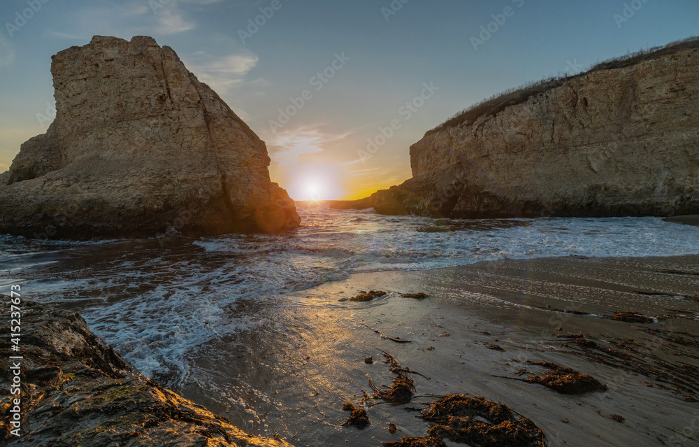 Fototapeta premium A picturesque sunset in Shark Fin cove, ocean, rocks, beautiful sky. Santa Cruz and Davenport have some of the most beautiful beaches in California.