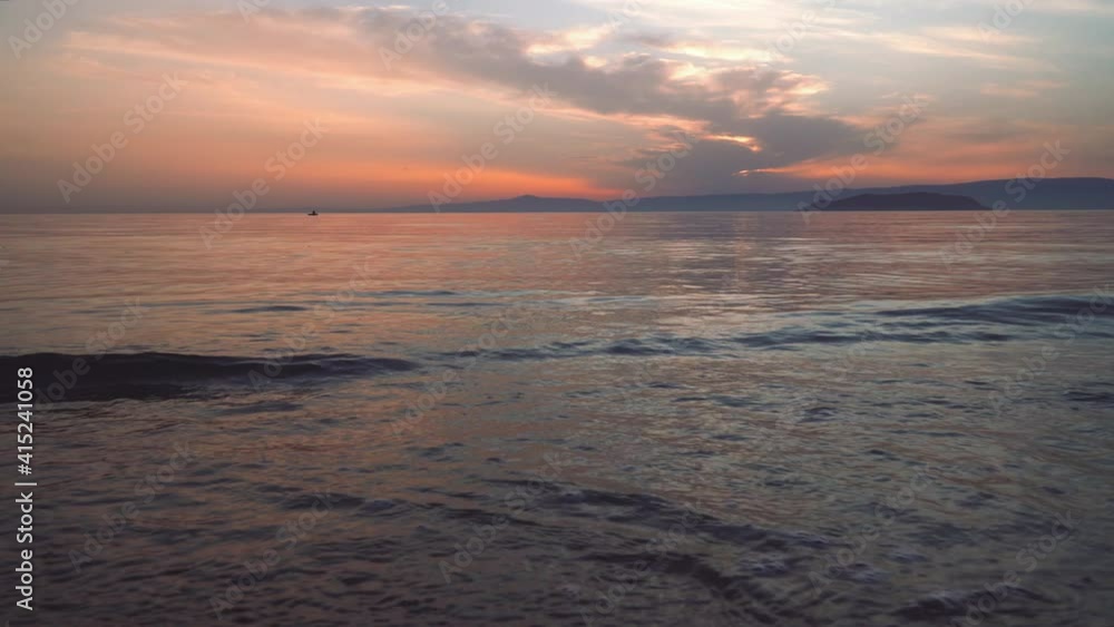 Relaxing wave audio and video in 4k resolution of a colorful sunset or sunrise reflecting over the sea with focus on water. Tranquility and peace. Meditation. Natural sky and sea background Relaxing wave audio and video in 4k resolution of a colorful sunset or sunrise reflecting over the sea with focus on water. Tranquility and peace. Meditation. Natural sky and sea background