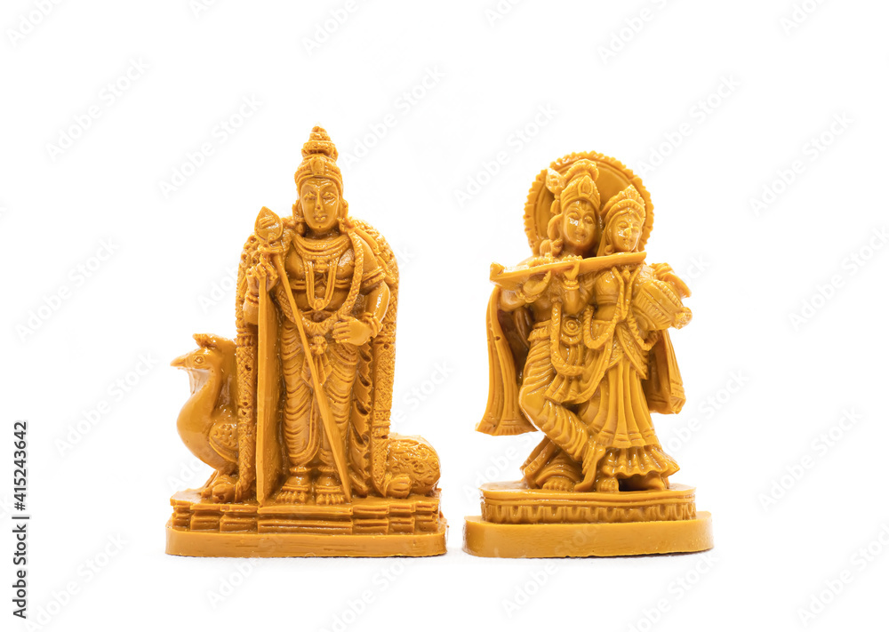 The hand-carved wooden idol of Lord Murugan with Radha Krishna is isolated on a white background The hand-carved wooden idol of Lord Murugan with Radha Krishna is isolated on a white background