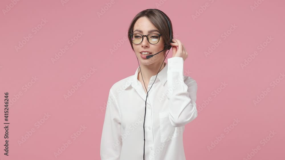 Beautiful business woman support agent operator in call center in white shirt glasses headset isolated on pink background studio. Achievement career wealth concept. Talk with customer client on phone Beautiful business woman support agent operator in call center in white shirt glasses headset isolated on pink background studio. Achievement career wealth concept. Talk with customer client on phone