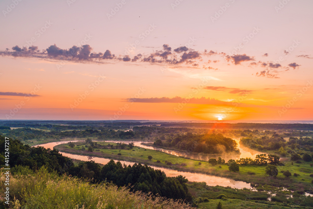 colorful sunrise on the background of a winding river with fog
