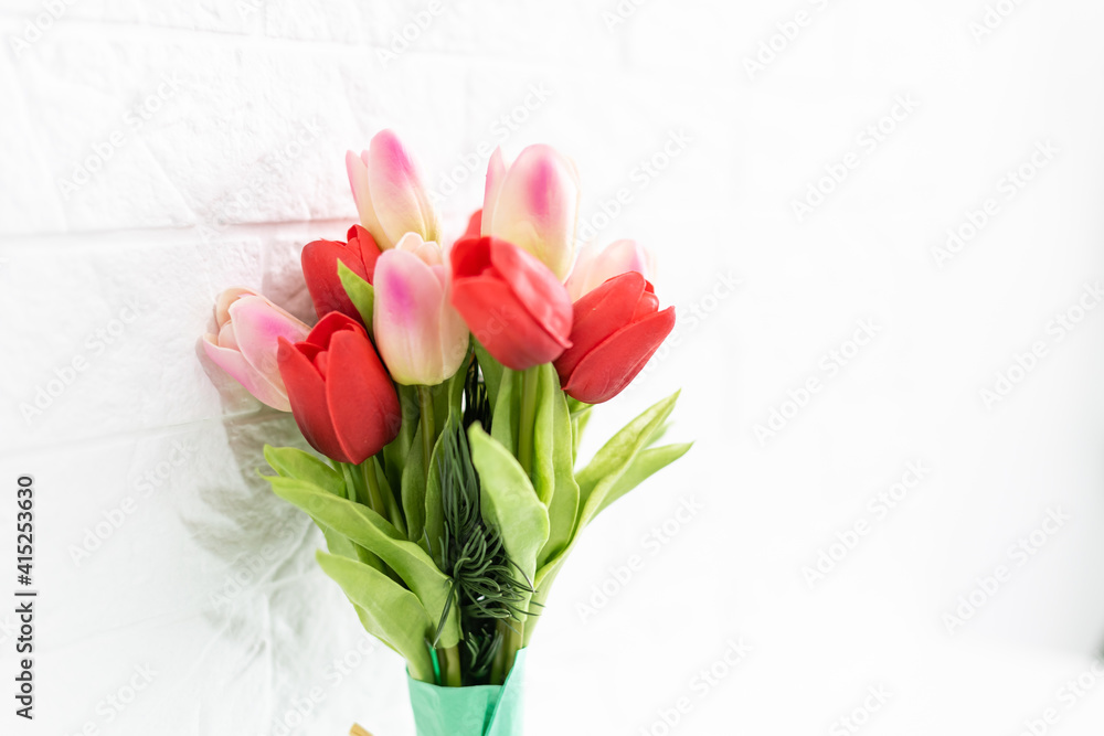 Bouquet of spring tulips with different color flowers wrapped in paper for present on white background Bouquet of spring tulips with different color flowers wrapped in paper for present on white background