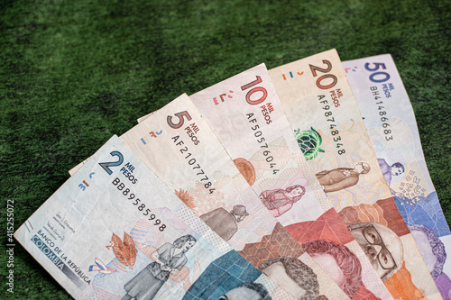 Colombian money on a textured green background
