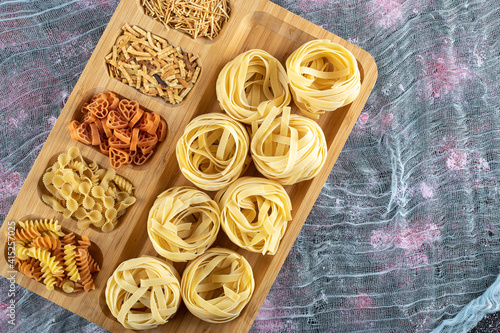 Raw fettuccine pasta on the wood backgroud ready for cooking photo