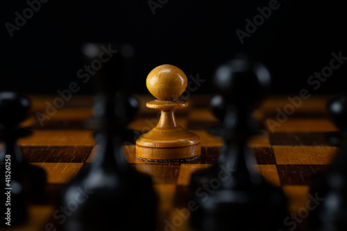 One white pawn against an army of black pieces on a chessboard