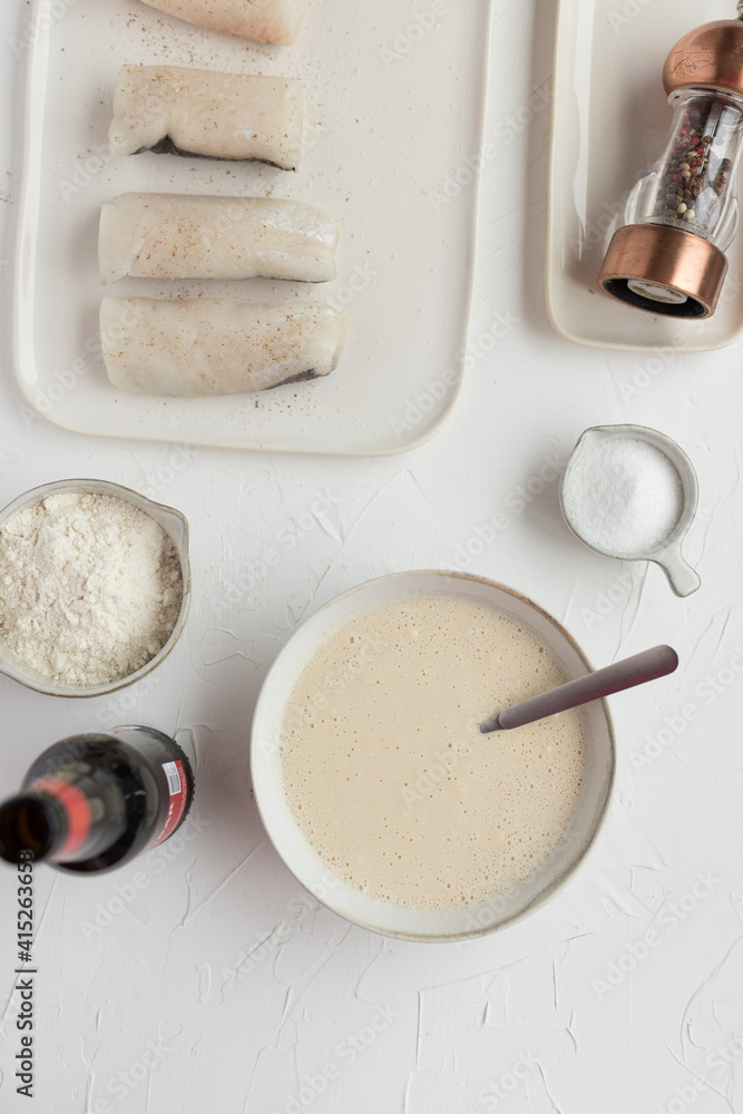 Overhead view of tempura ingredients next to a final tempura butter ready to fry hake loins. Overhead view of tempura ingredients next to a final tempura butter ready to fry hake loins.
