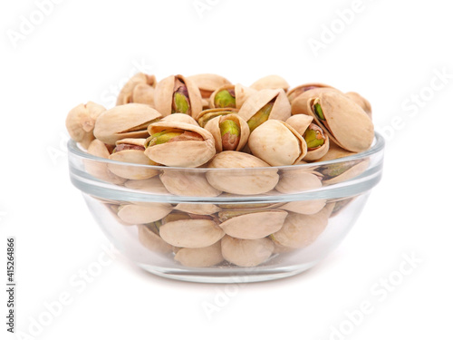 Salted pistachios in a glass bowl isolated on white 