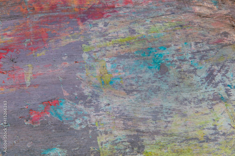 colorful creative motley background: smudged residues of oil paints on a wooden palette, short focus, selective blur