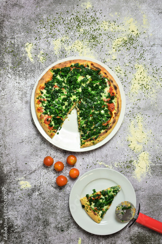Spinach pizza with mozzarella and tomato on a stone base. Copy space