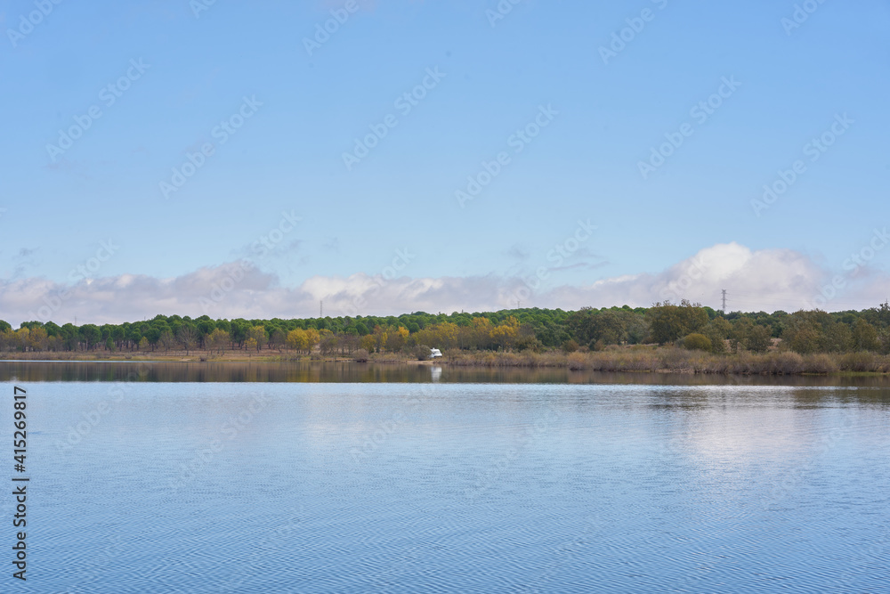Lake view of a camper van with solar panel living van life panorama landscape with reflection on the water in Marateca Dam in Castelo Branco, Portugal