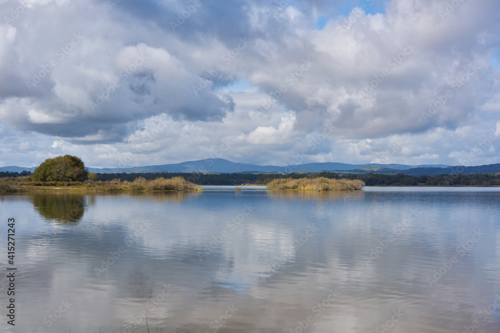 Lake dam landscape with reflection of Gardunha mountains and trees on a cloudy day in Santa Agueda Marateca Dam in Portugal