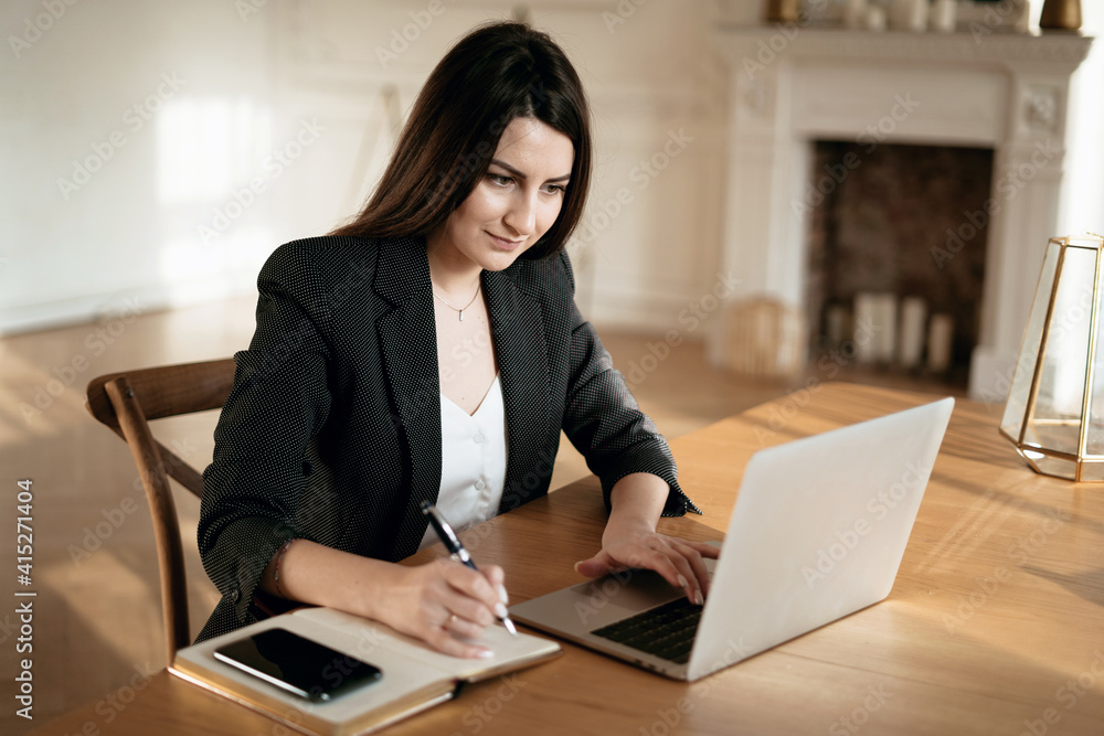 A woman in a business suit. Works in a modern office. New project at work. The lawyer is sitting next to the laptop. Space for copying. Accountant Manager Student beautiful brunette. A woman in a business suit. Works in a modern office. New project at work. The lawyer is sitting next to the laptop. Space for copying. Accountant Manager Student beautiful brunette.