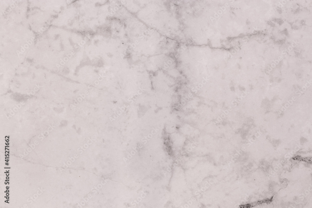 An abstract shot of a white tile with a grey marbled design.