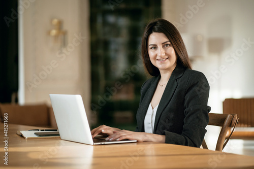 The chief Accountant of the Student to the fundamentals of the economy. Online training in a modern office. An economist in a business suit. Sitting in a chair and reading on an electronic textbook.
