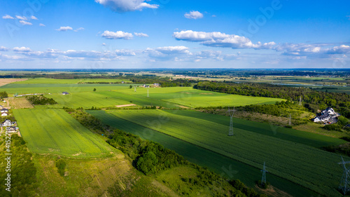 Aerial view of green agricultural fields in summer, nicely covered by shadows from clouds