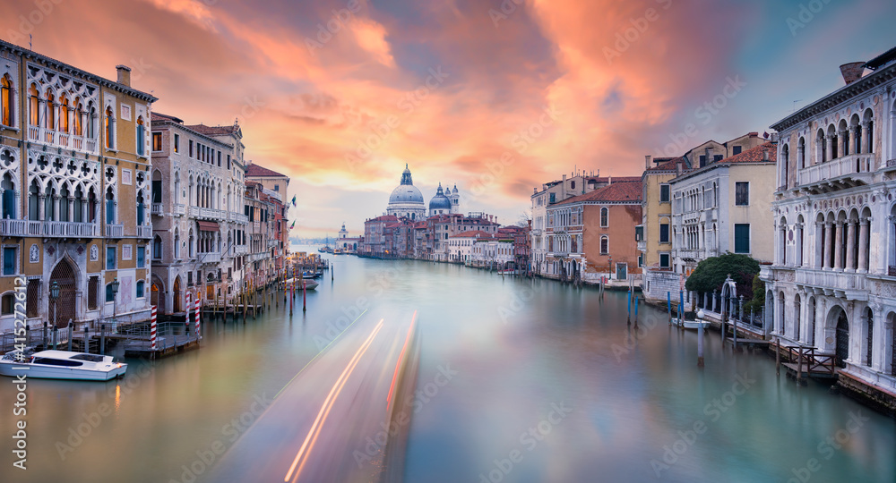 Stunning view of the Venice skyline with the Canal Grande and the Basilica Santa Maria Della Salute in the distance during a beautiful sunrise. Venice, Italy.