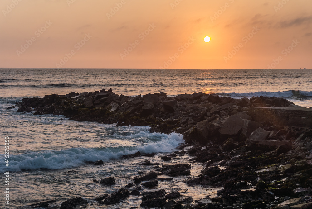 Beautiful sunset in the shore of Lima Peru, pile of rocks, organge sky Beautiful sunset in the shore of Lima Peru, pile of rocks, organge sky